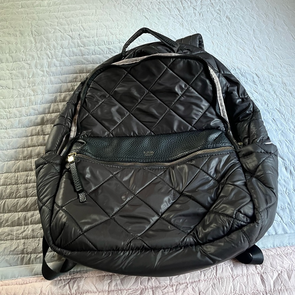 Tutilo backpack. Black outside a tan-ish peachy purple color on the inside. Soft